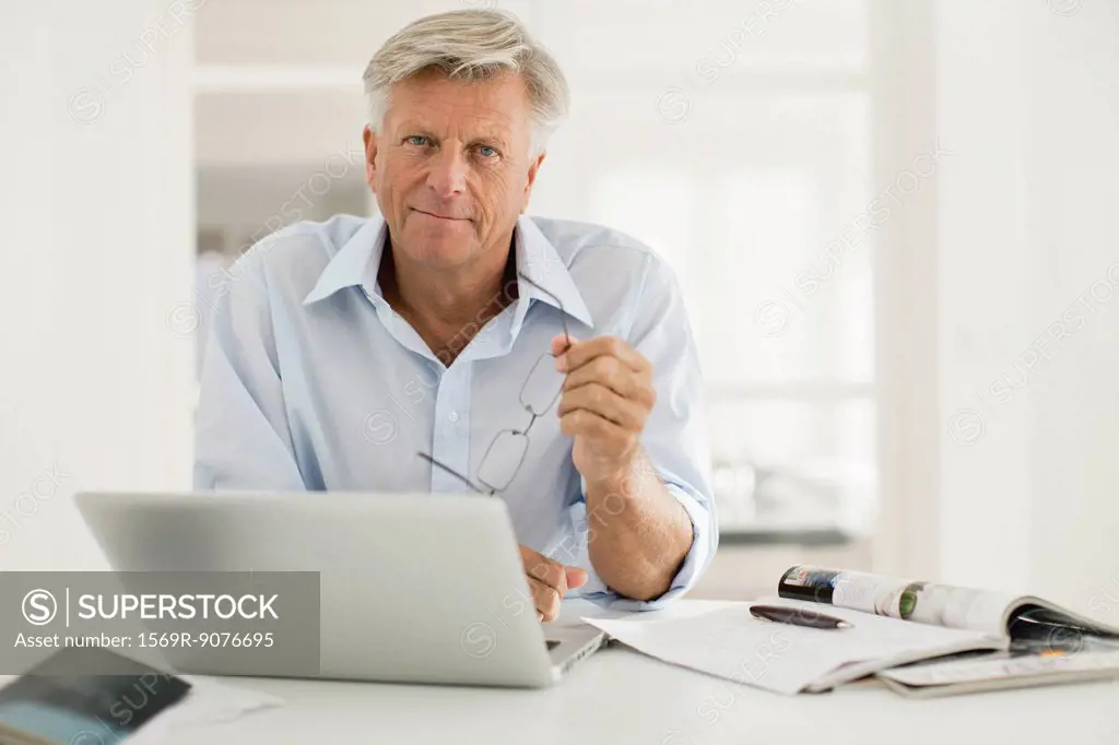 Senior man using laptop computer at home