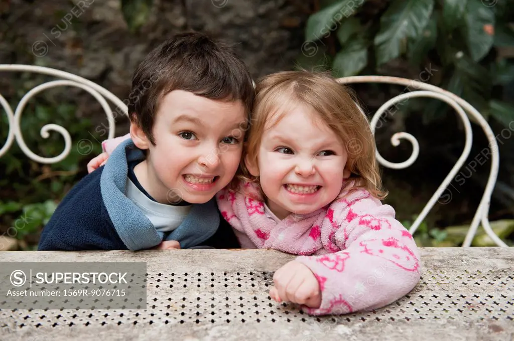 Young brother and sister smiling together outdoors, portrait