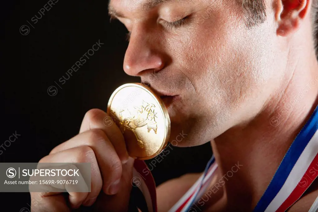 Athlete kissing gold medal