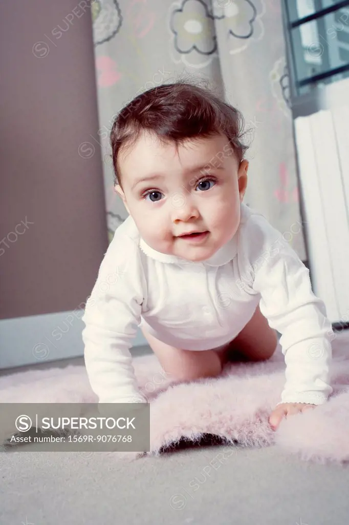 Infant crawling on floor, portrait