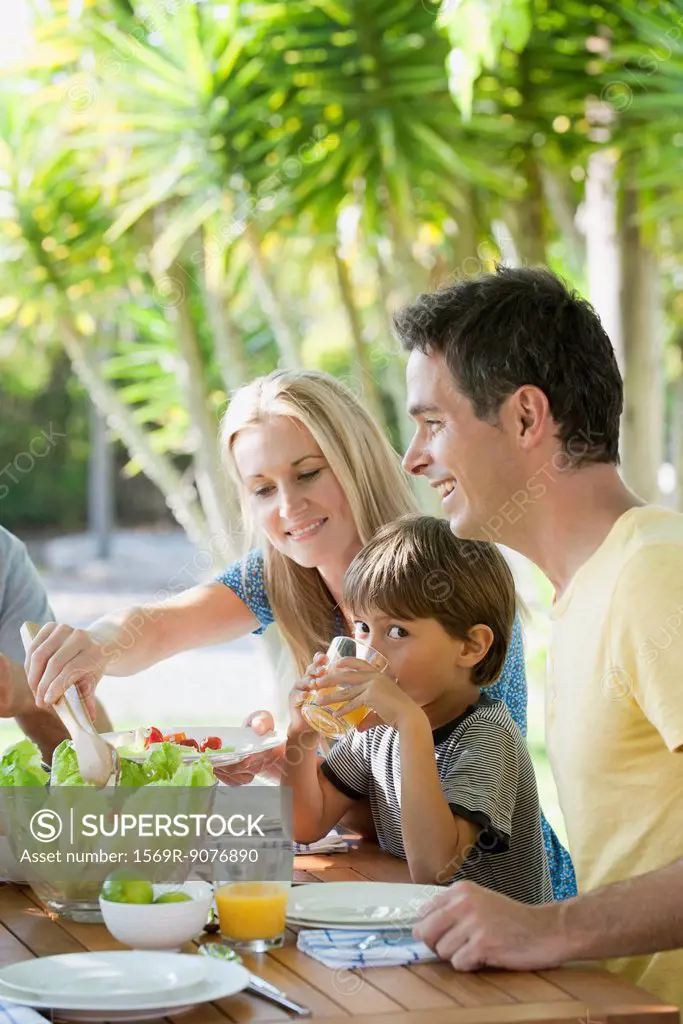 Parents and young son having breakfast outdoors