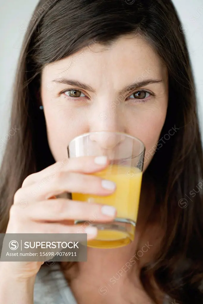 Mid_adult woman drinking orange juice