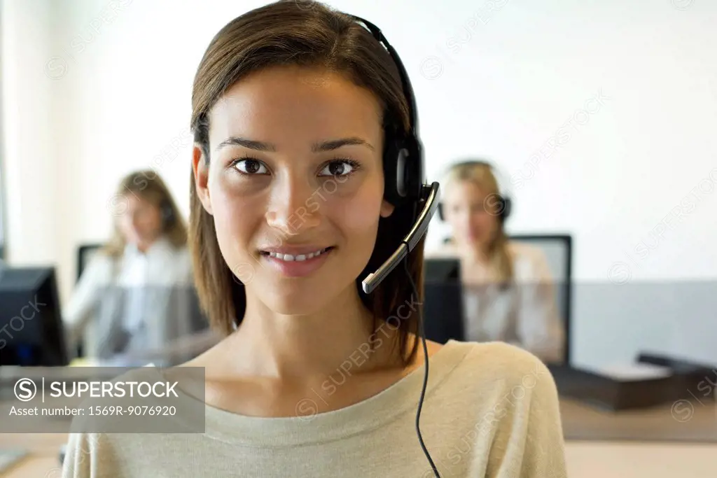 Woman using headset in office, portrait