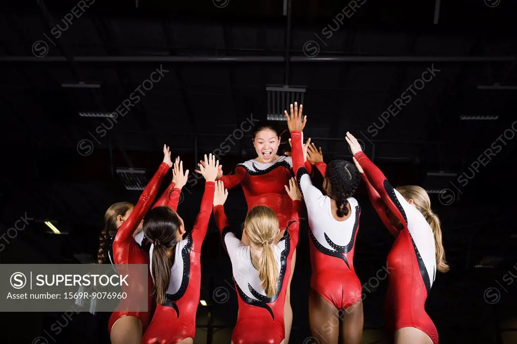 Team of female gymnasts celebrating victory together