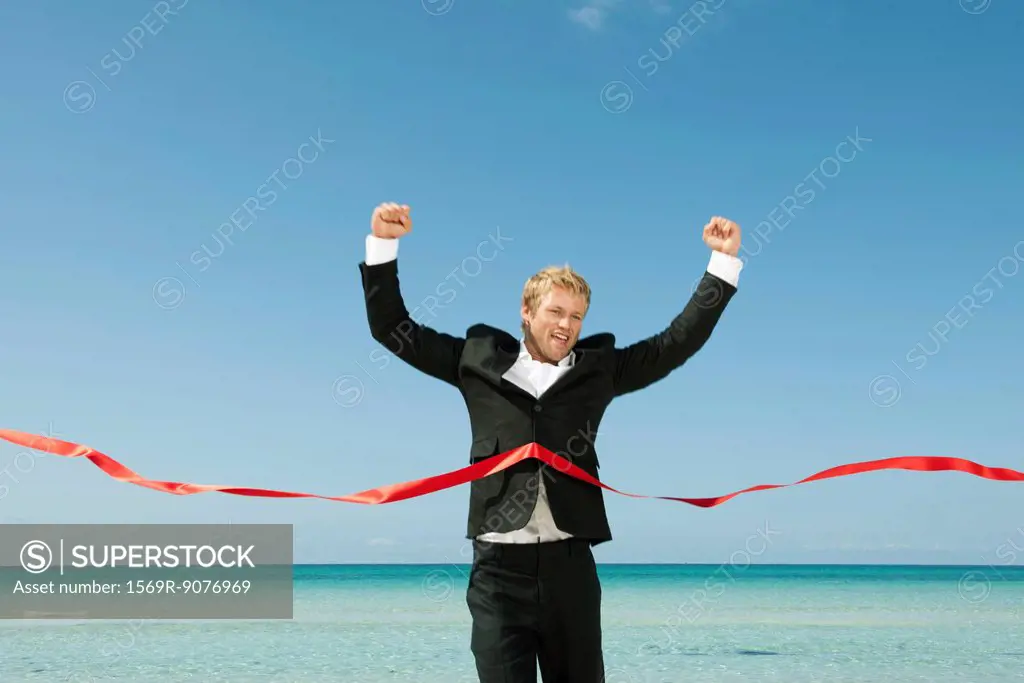 Young businessman crossing finishing line