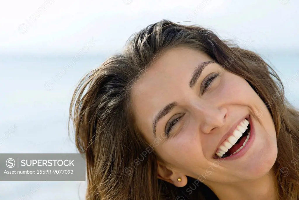 Young woman outdoors, smiling cheerfully, portrait