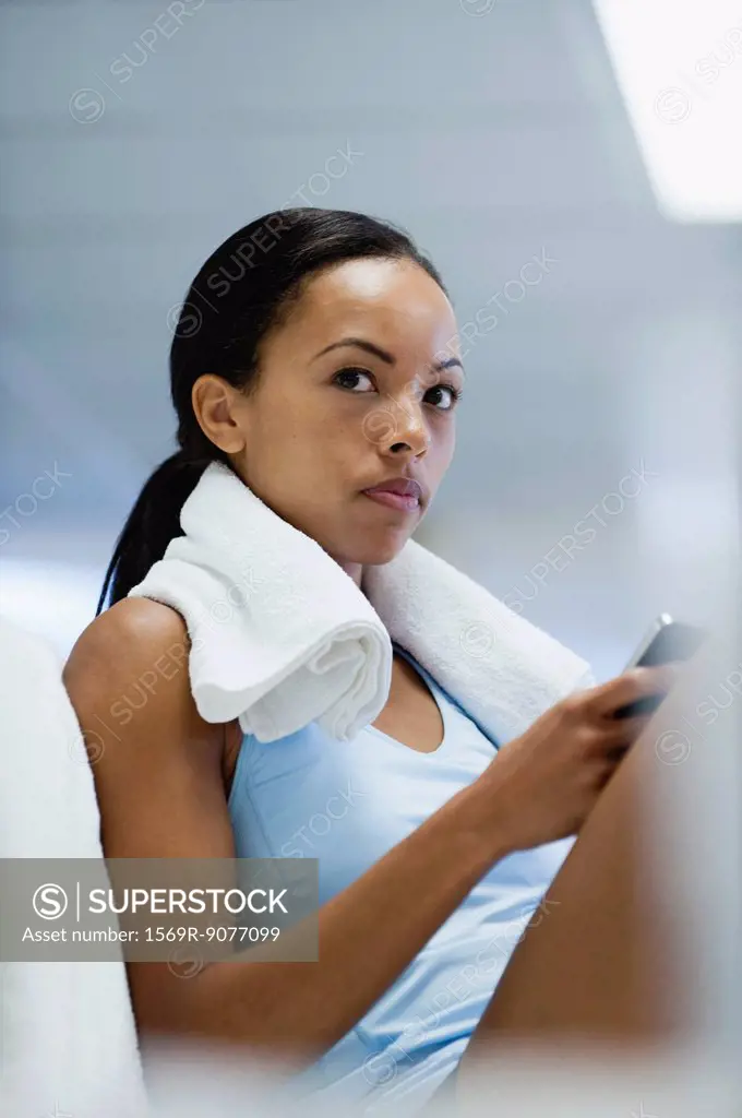 Young woman in sports clothing using cell phone