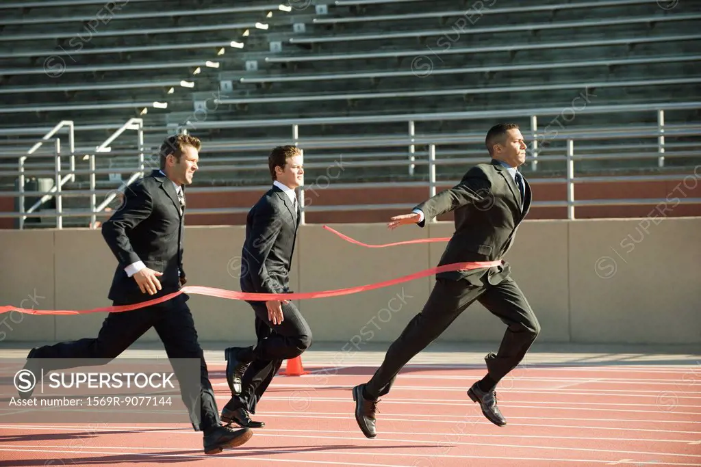 Businessman crossing finish line in race