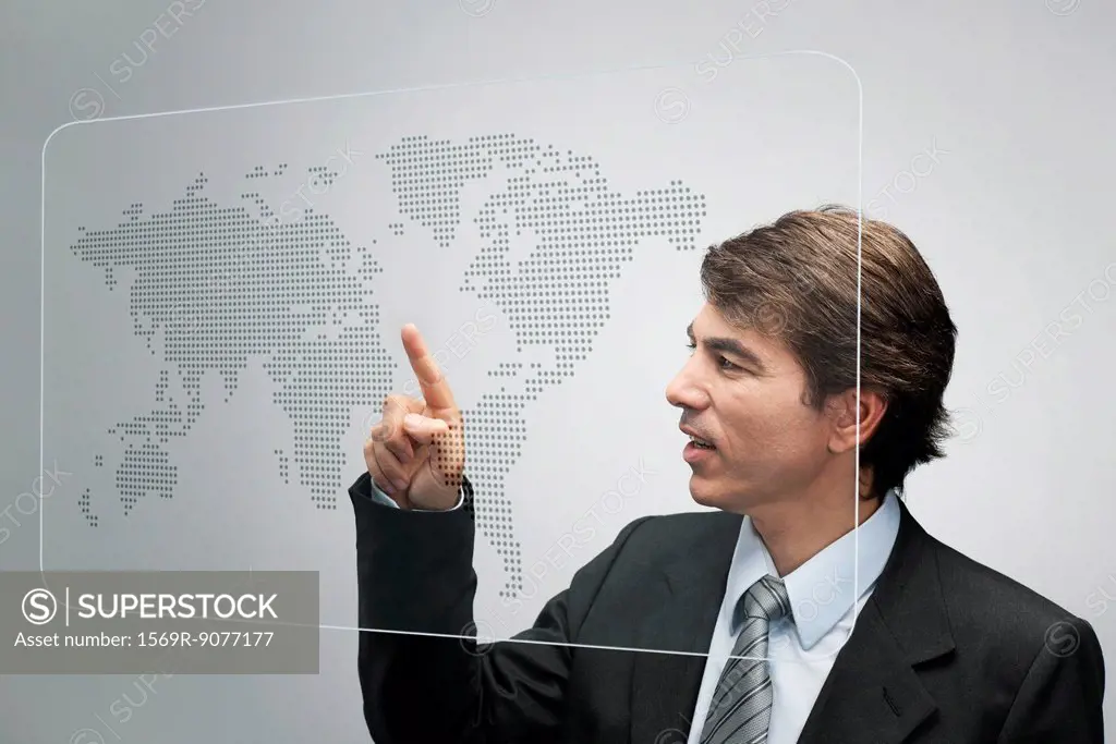 Businessman using advanced touch screen technology to view world map