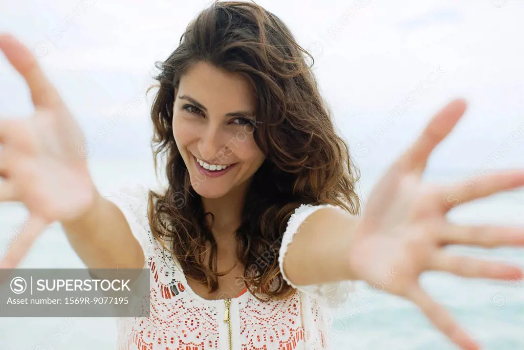 Woman reaching arms toward camera, smiling