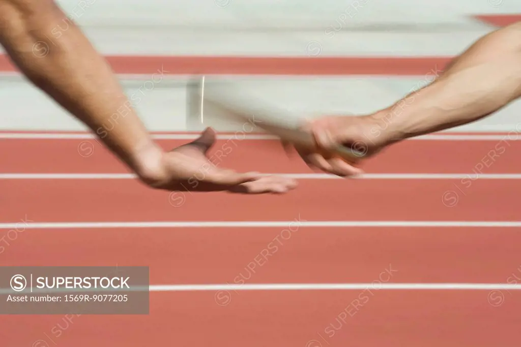 Runners exchanging baton in relay race, cropped