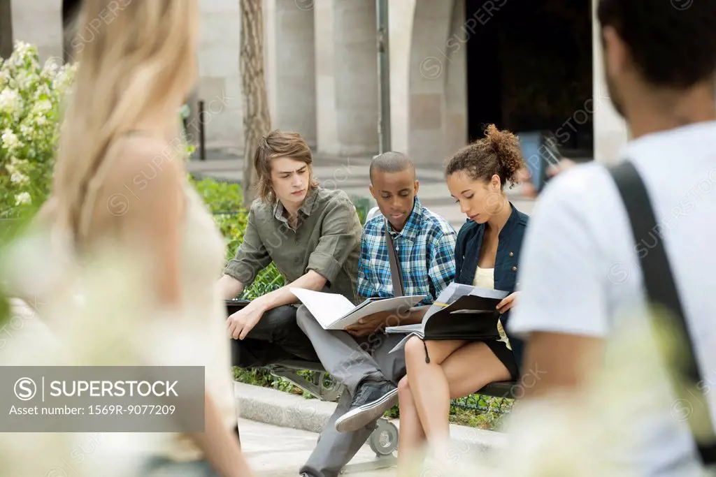 University students studying on campus, people in foreground