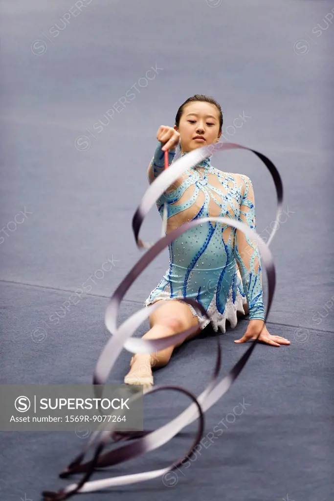 Female gymnast performing floor routine with ribbon