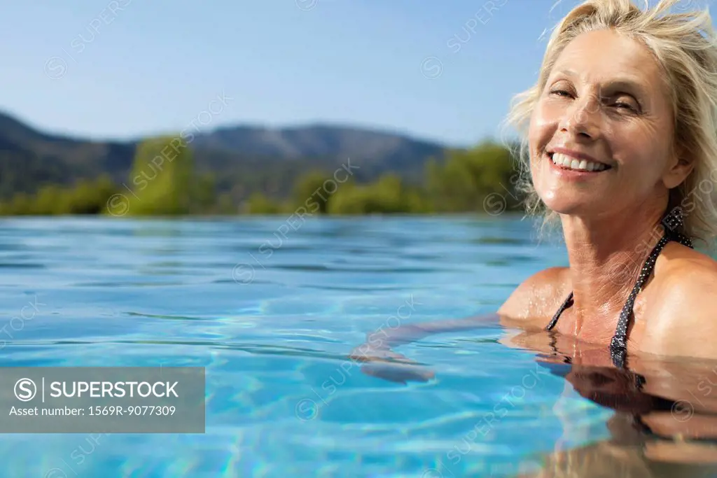 Mature woman relaxing in pool, portrait