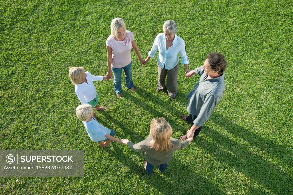 People standing together holding hands forming circle