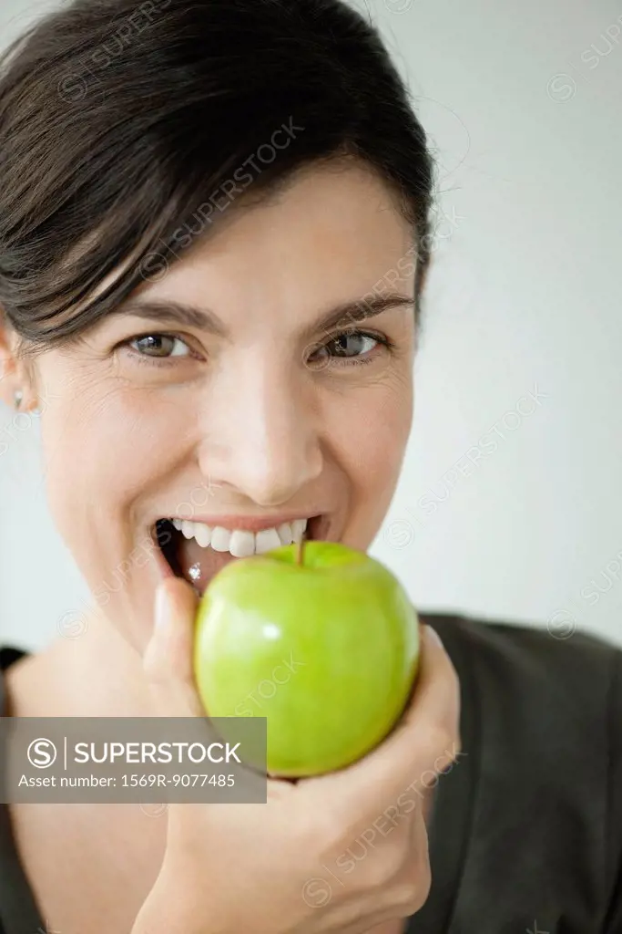 Mid_adult woman biting into apple