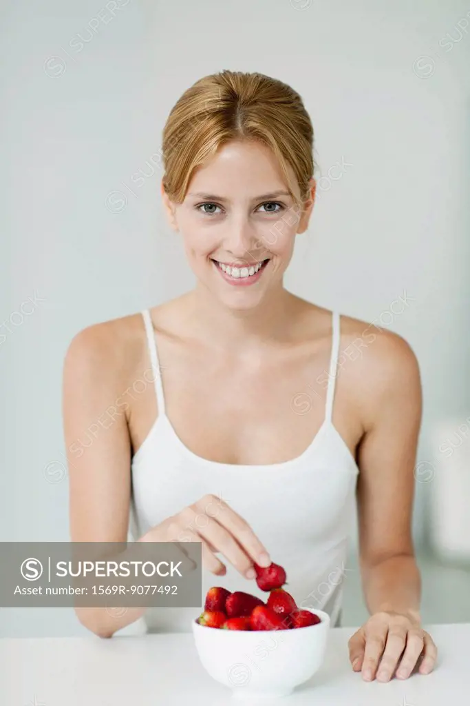 Young woman with bowl of strawberries