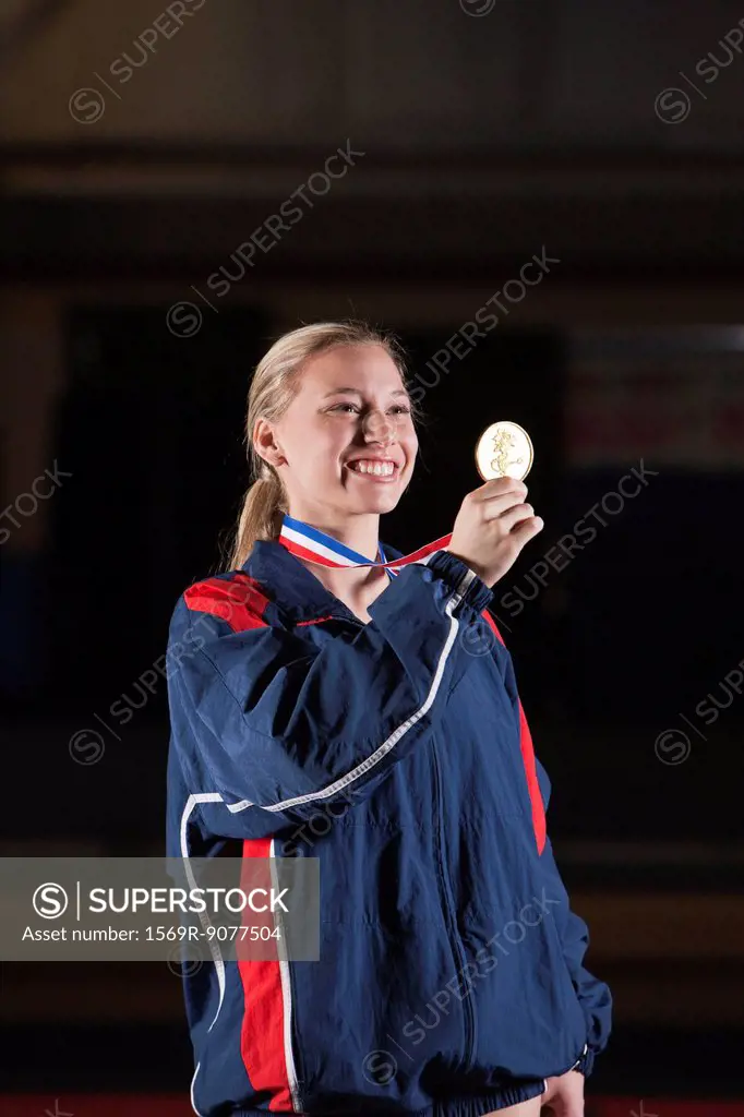 Smiling female athlete holding gold medal