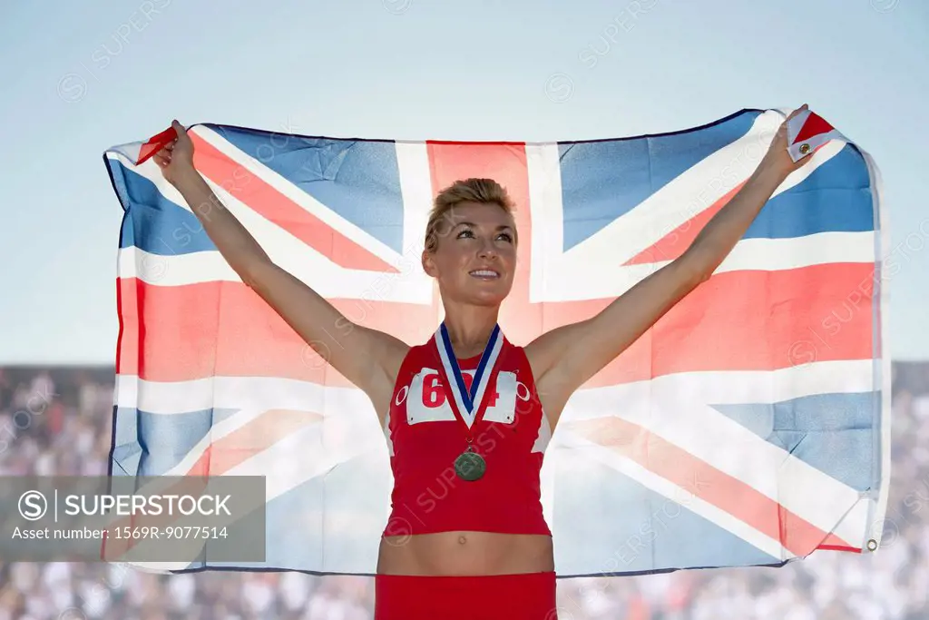 Young female medalist holding up British flag