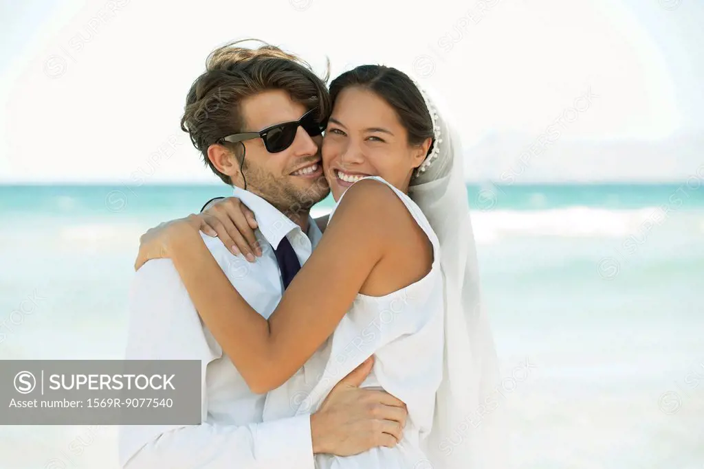 Bridge and groom embracing at the beach, portrait