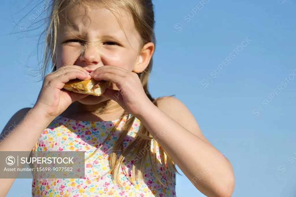 Girl eating sandwich outdoors