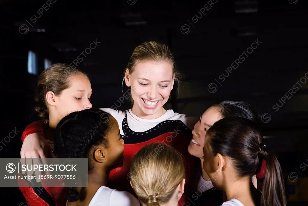 Team of female gymnasts embracing