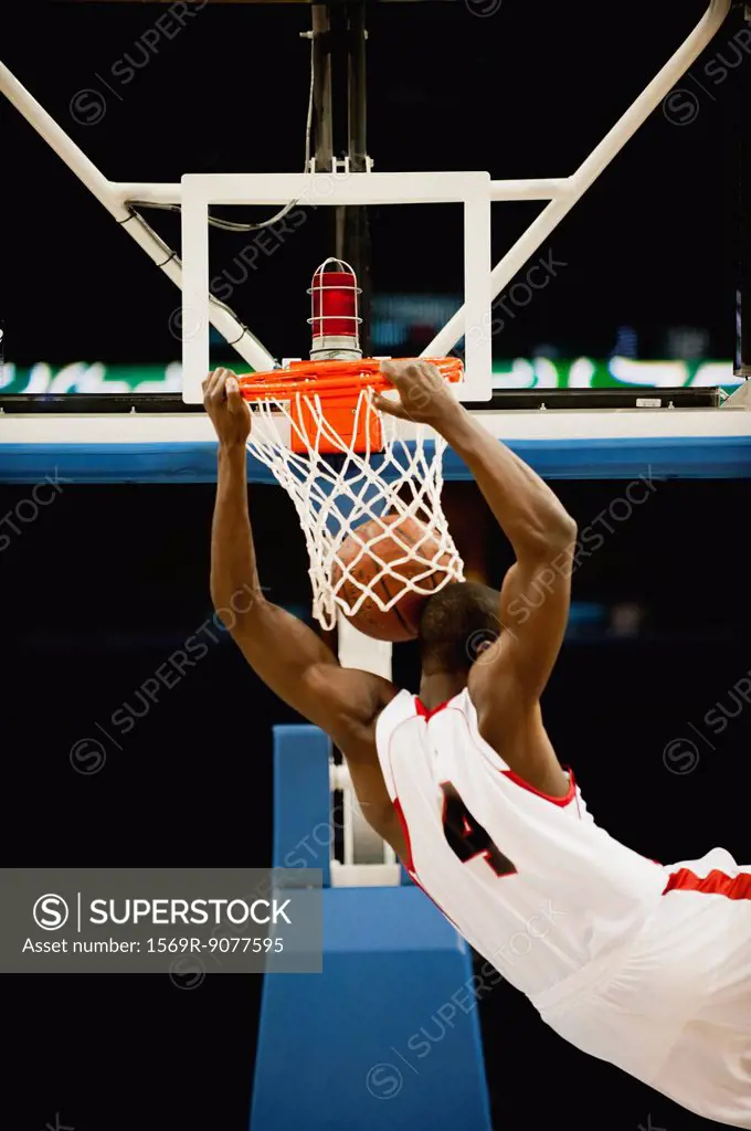 Basketball slam dunking, rear view