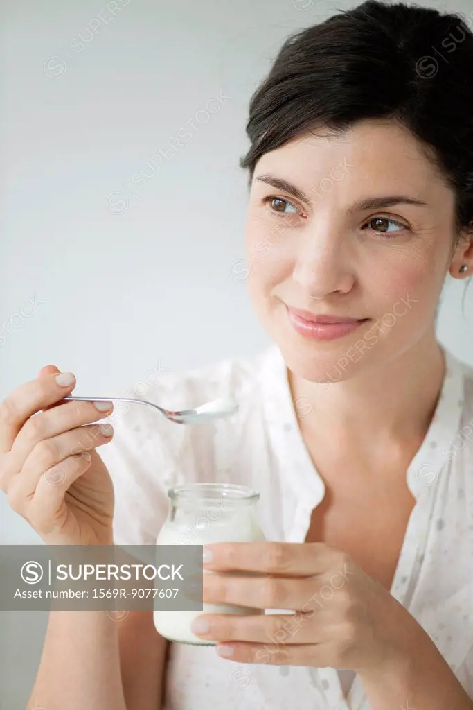 Mid_adult woman eating yogurt, portrait