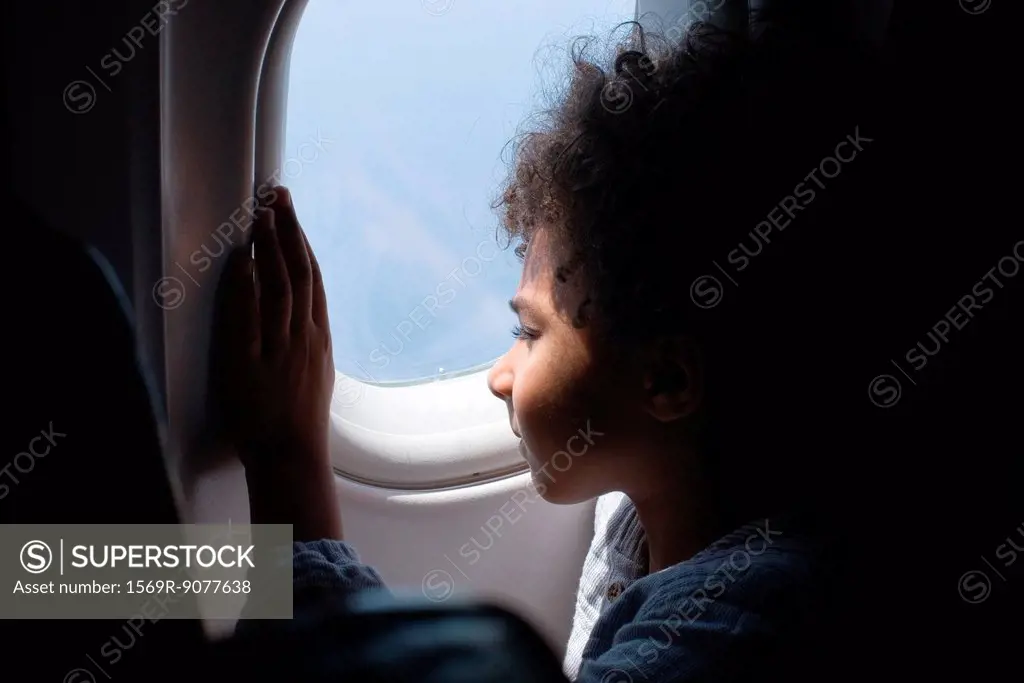 Boy looking out airplane window