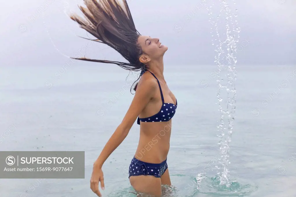 Woman tossing wet hair in water