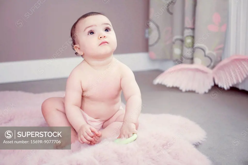 Baby sitting on rug, portrait
