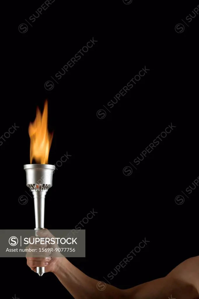 Man´s hand holding torch with no flame, cropped