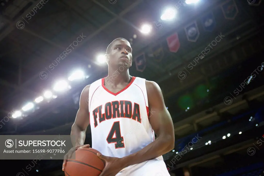 Basketball player holding basketball low angle view