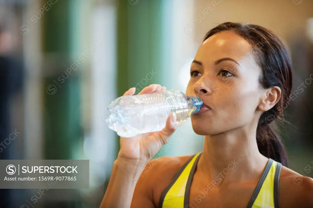Young woman drinking bottle of water