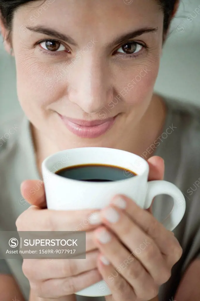 Mid_adult woman holding cup of coffee