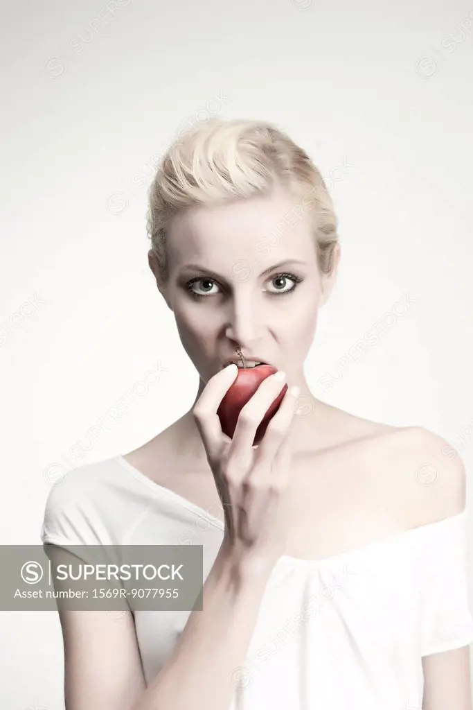 Young woman biting into apple, portrait