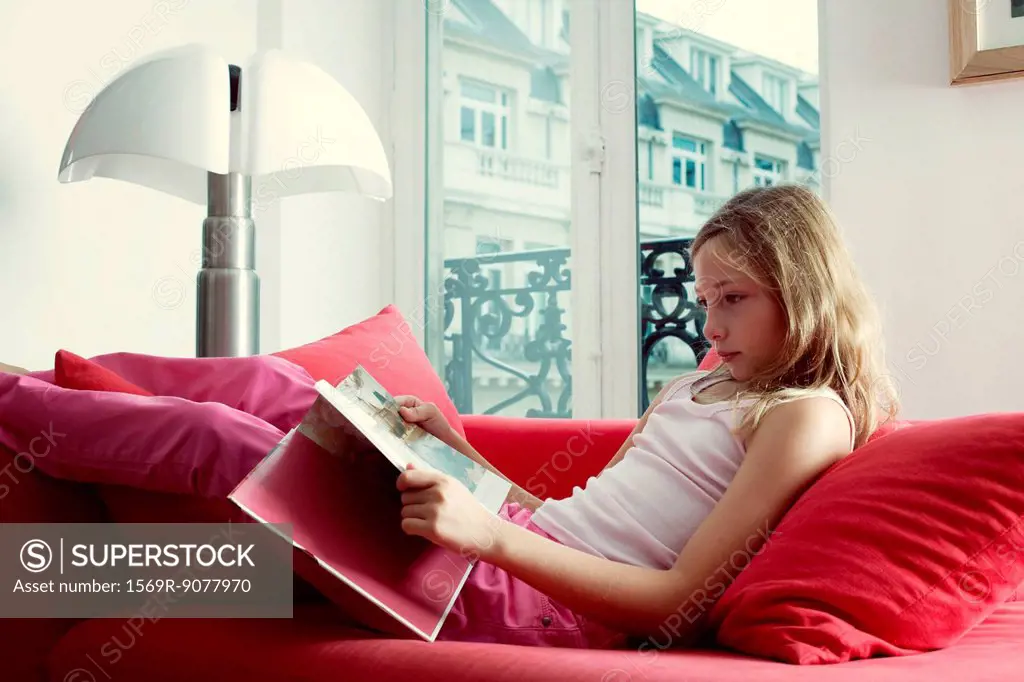Girl relaxing on couch reading book
