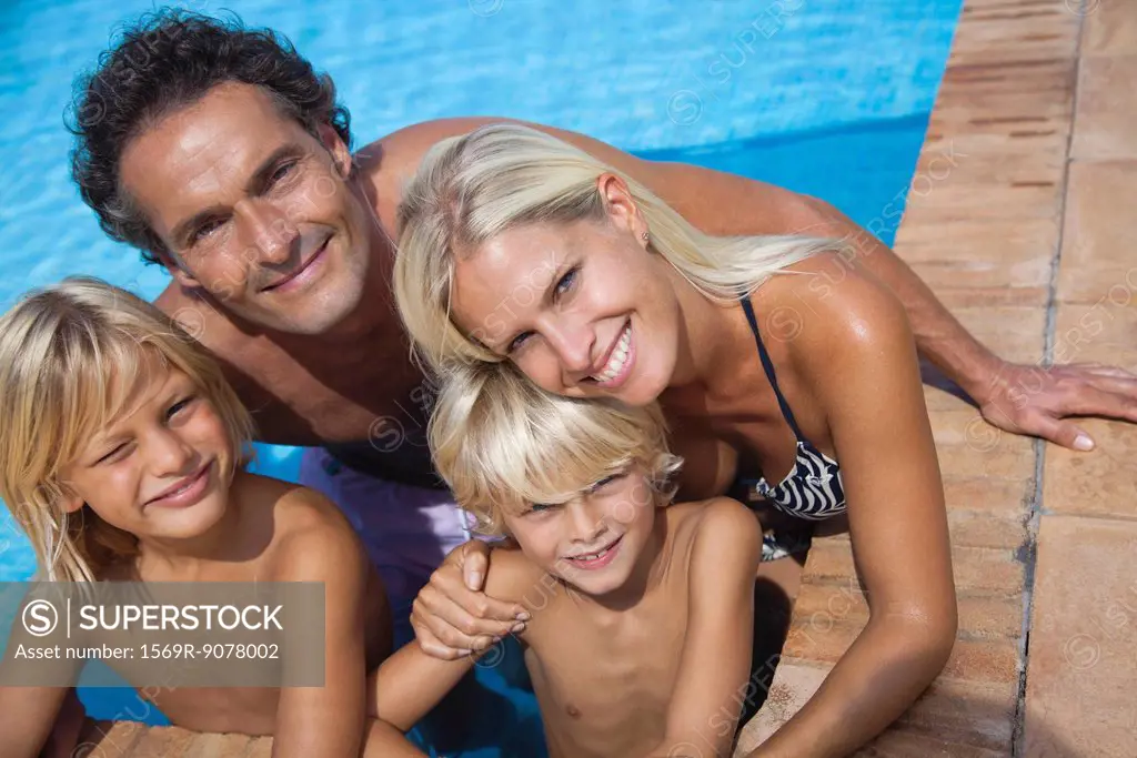 Family relaxing together in swimming pool, portrait