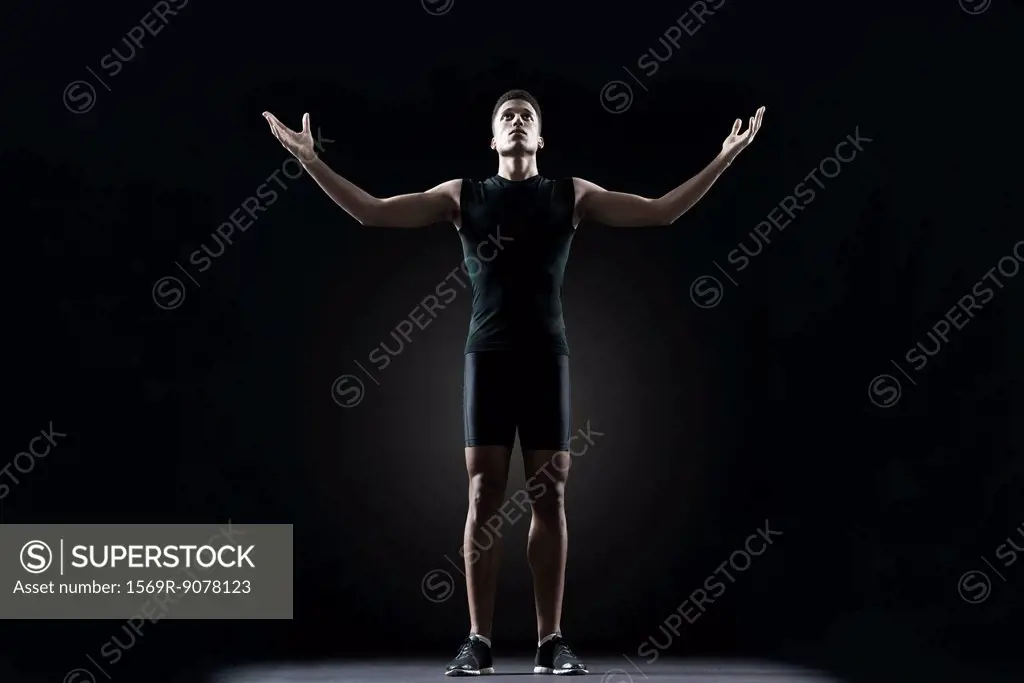 Male athlete with arms outstretched, portrait