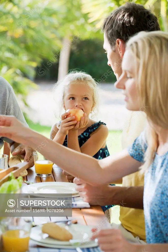 Girl having meal with family outdoors