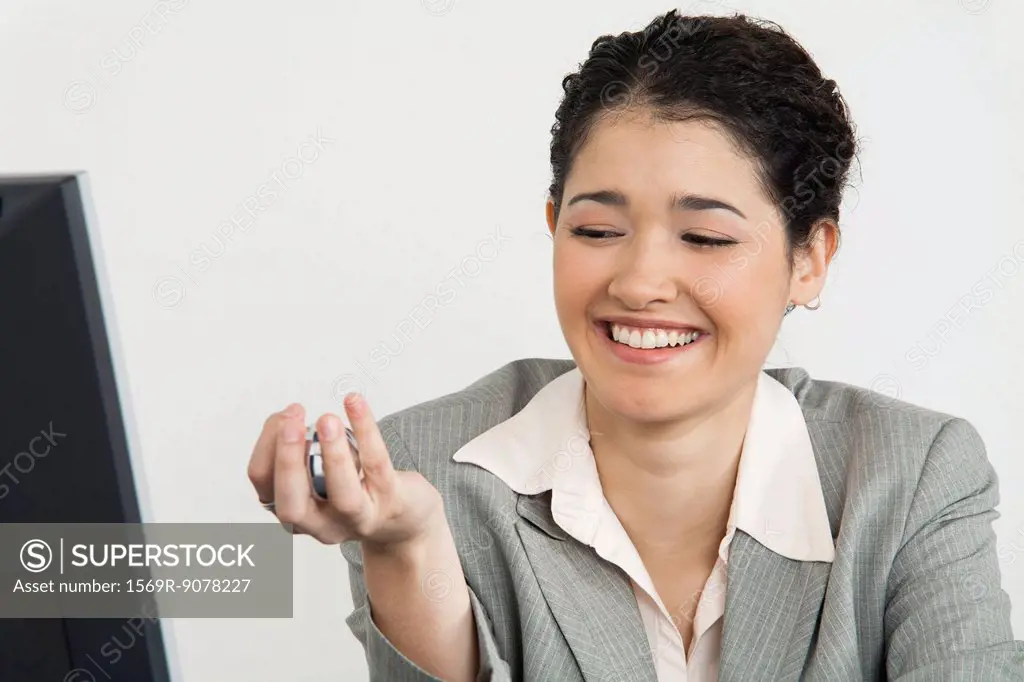 Young businesswoman holding yin yang balls, smiling