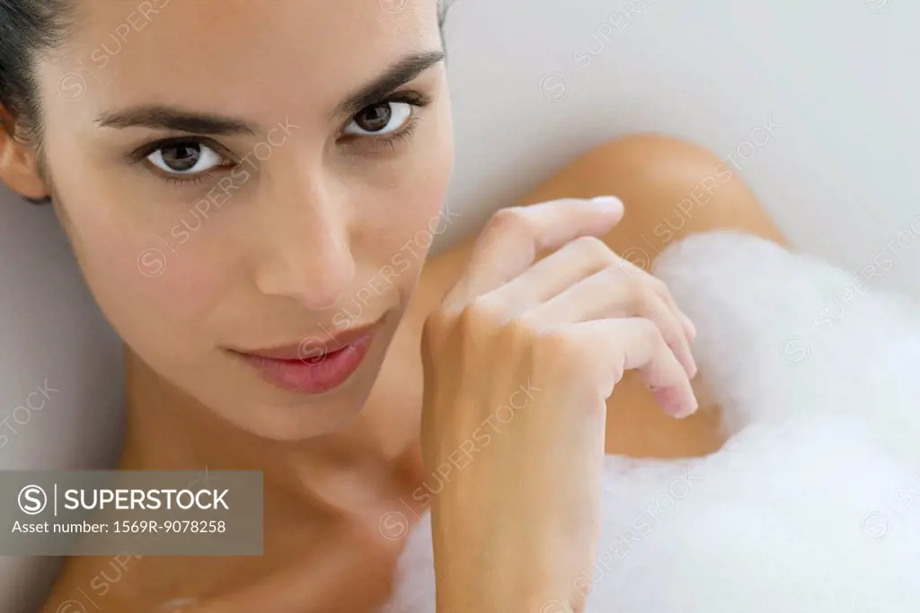 Woman soaking in bubble bath, portrait