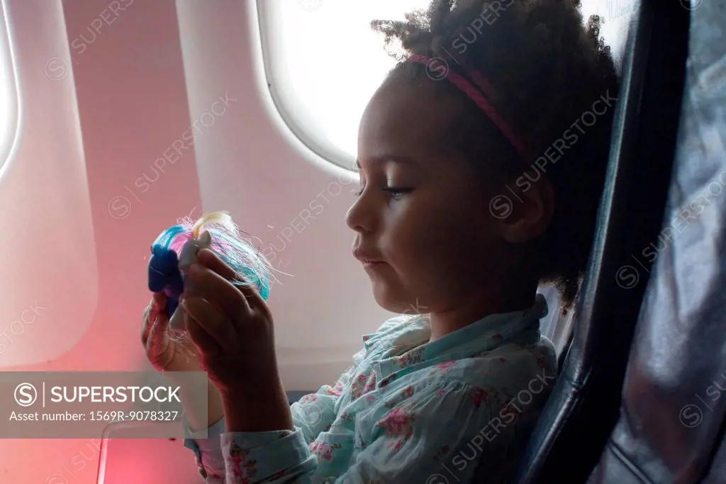 Little girl playing with toys on airplane