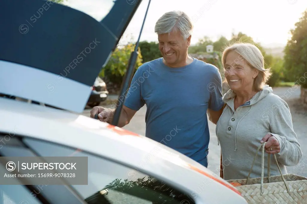 Couple loading bags into car