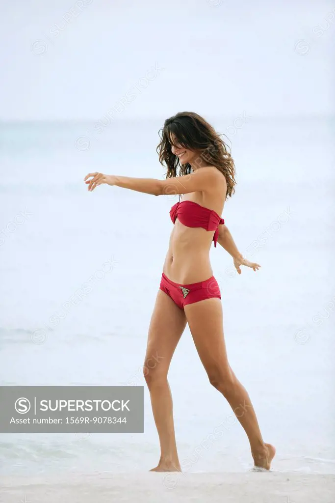 Woman in bikini walking in surf at the beach