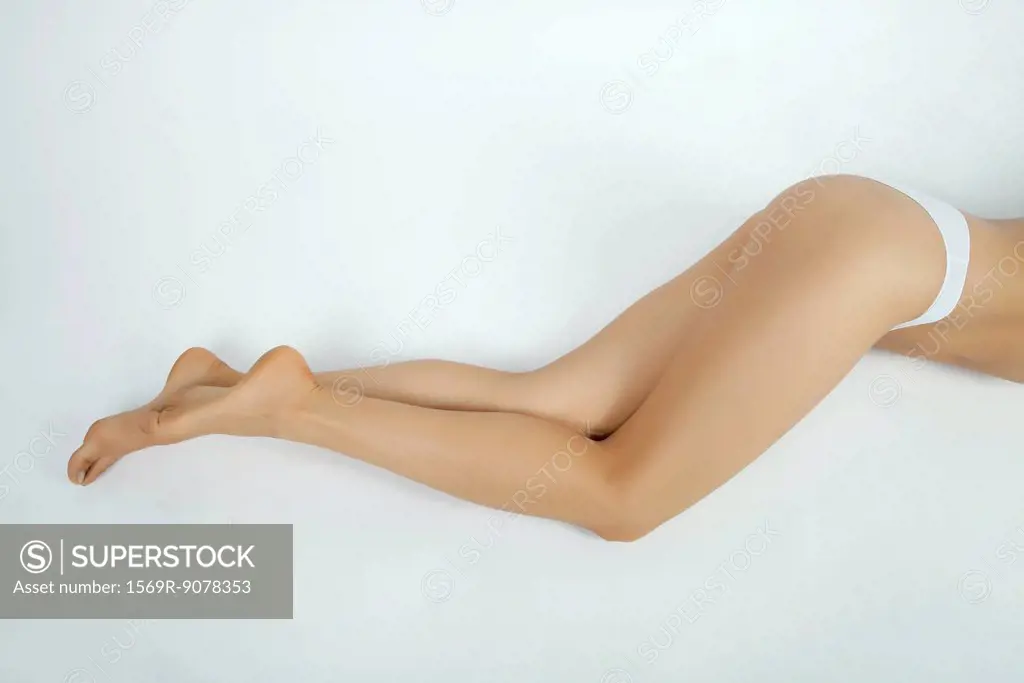 Woman lying down in underwear, low section