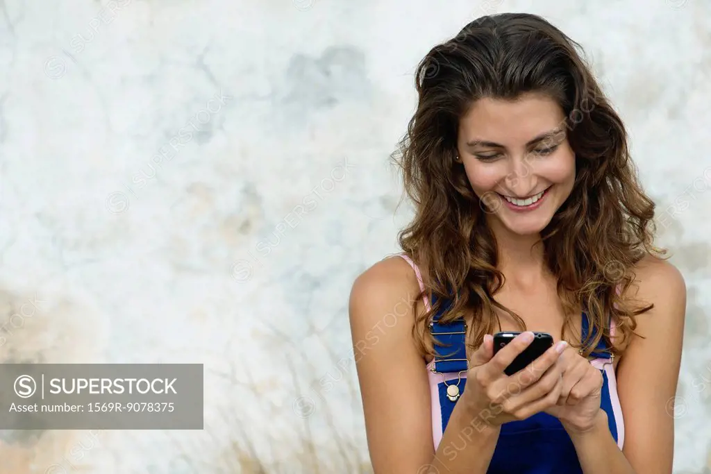 Young woman text messaging with cell phone