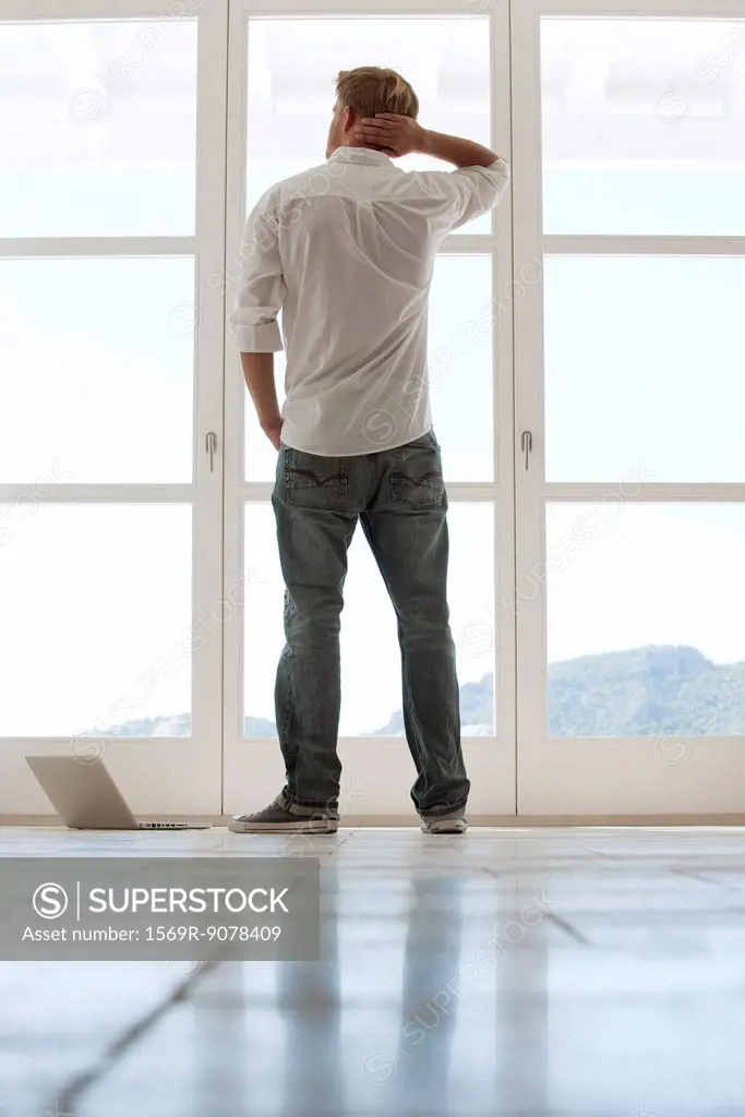 Man looking out window, rear view