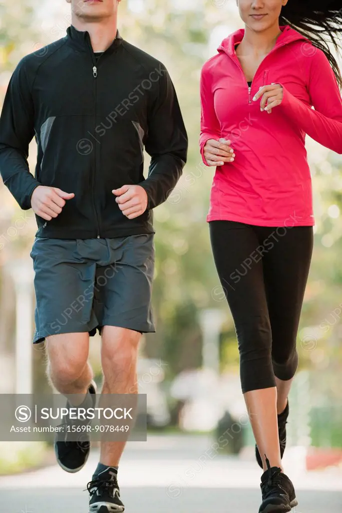 Couple jogging side by side, cropped