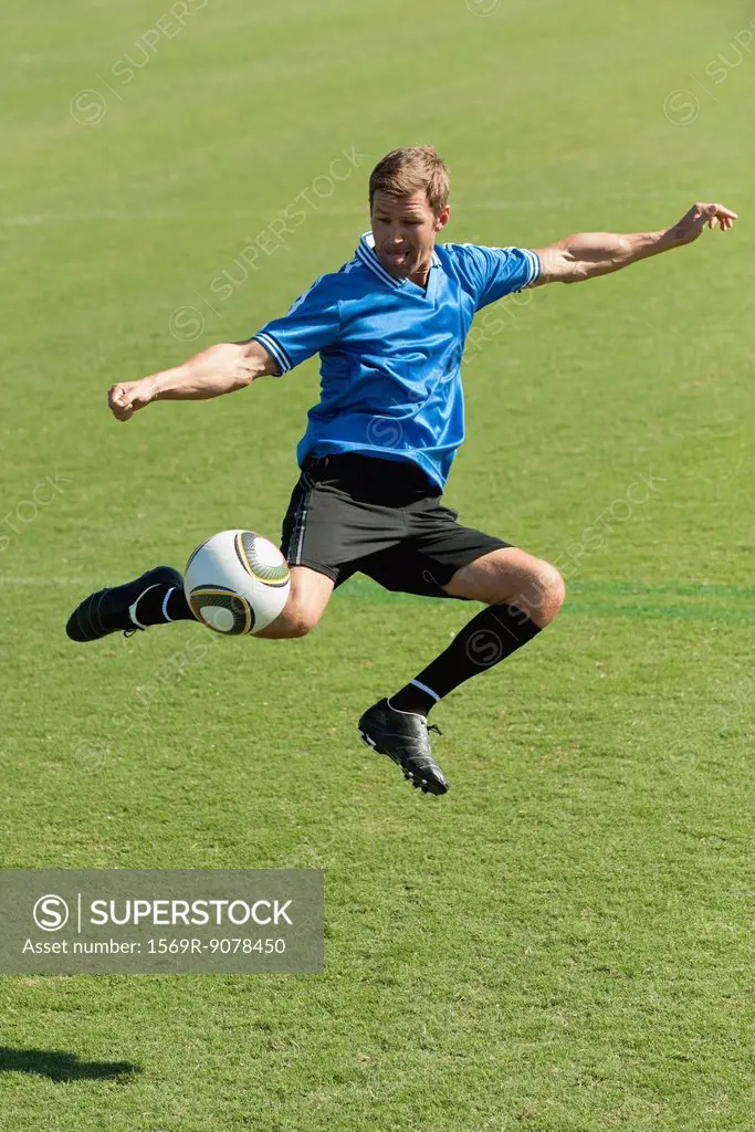 Soccer player kicking ball in midair